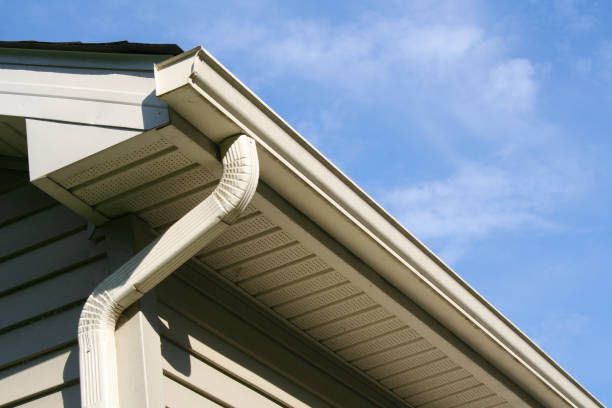 A house with a white gutter and a blue sky in the background