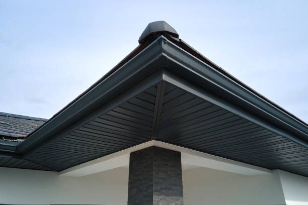 The roof of a house has a black gutter and a chimney.