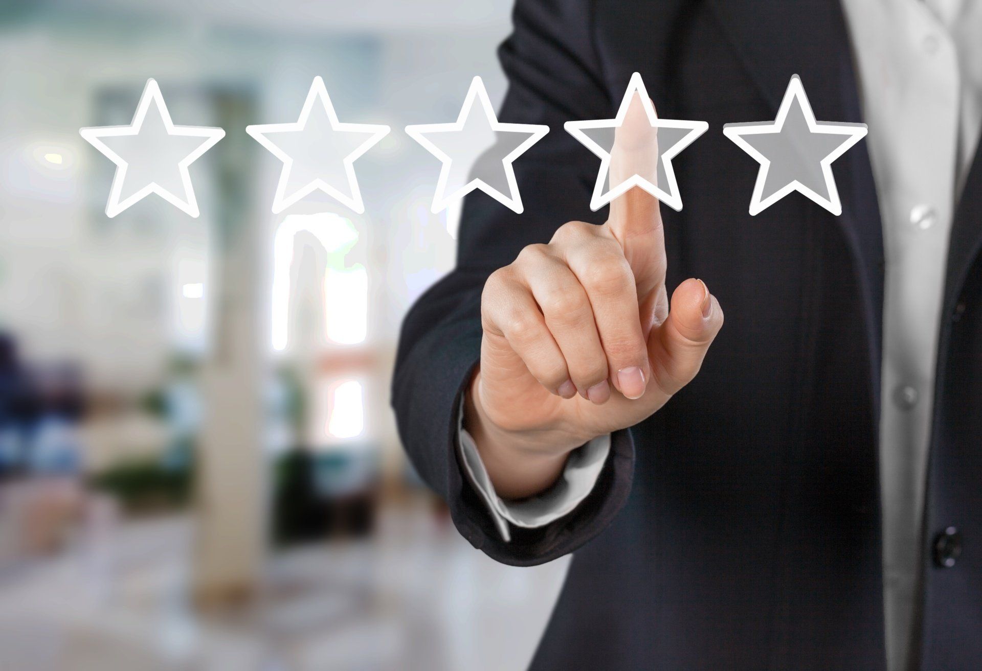 A man in a suit is pointing at five stars on a screen.