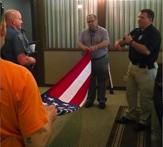 A group of men standing around an american flag