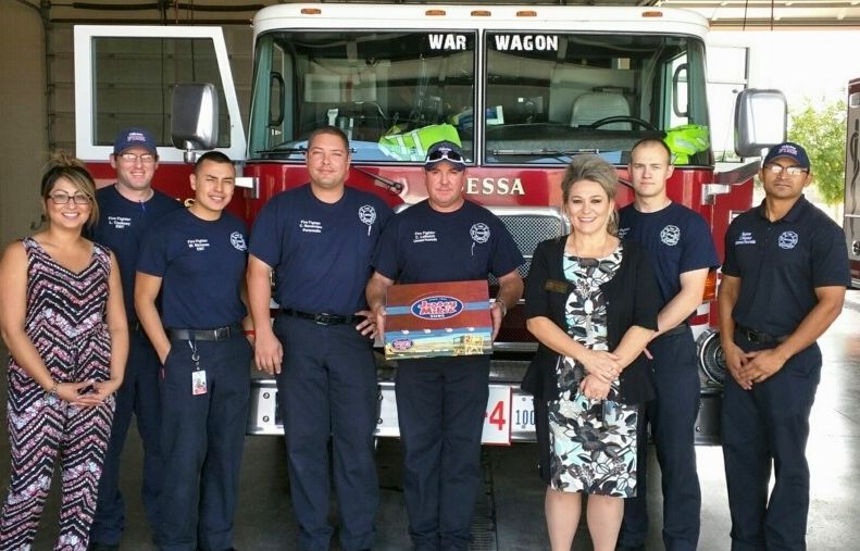 A group of firefighters are posing in front of a fire truck
