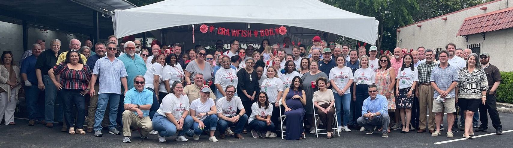 A large group of people are posing for a picture in front of a tent.