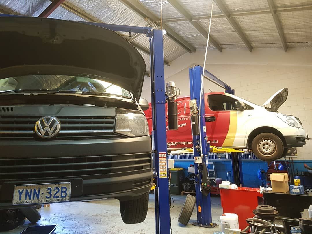 A Volkswagen Van Is Sitting on A Lift in A Garage — Latin Motors in Fyshwick, ACT
