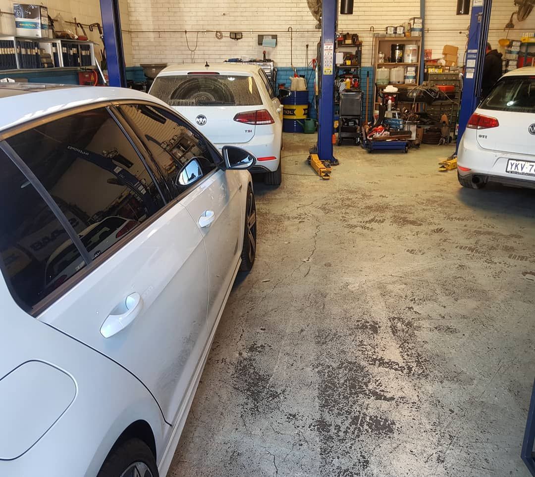 A White Car Is Parked in A Garage with Other Cars — Latin Motors in Canberra, ACT