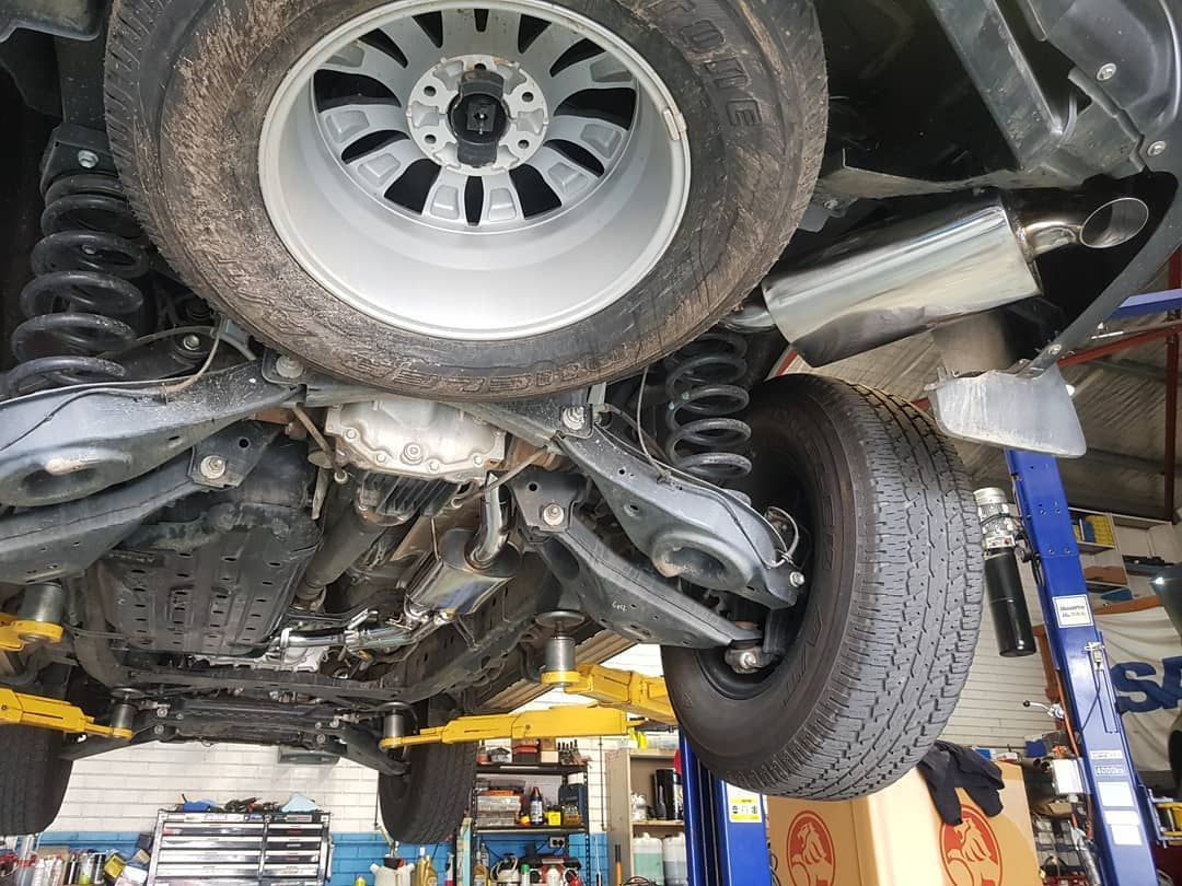 A Car Is Sitting on A Lift in A Garage — Latin Motors in Fyshwick, ACT