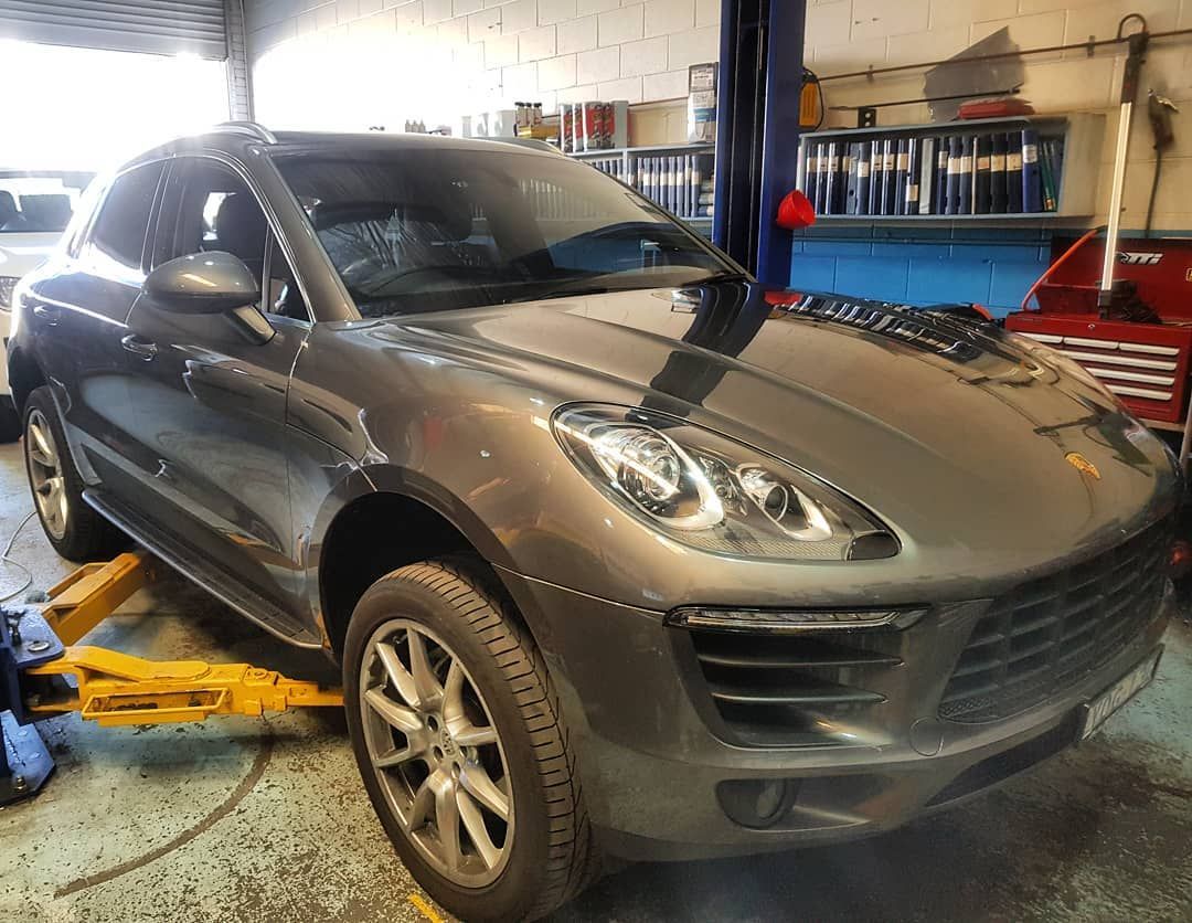 A Porsche Macan Is Sitting on A Lift in A Garage — Latin Motors in Queanbeyan, ACT