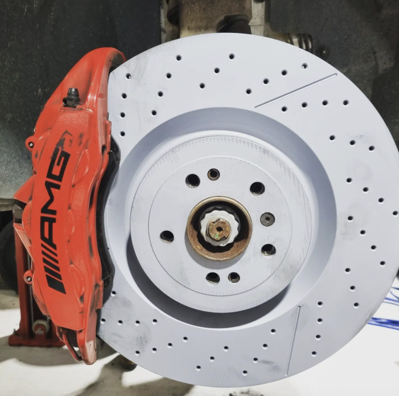 A Red AMG Brake Caliper Sits on A White Brake Disc — Latin Motors in Fyshwick, ACT