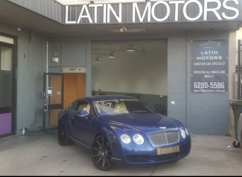 A Blue Car Is Parked in Front of A Building that Says Latin Motors — Latin Motors in Fyshwick, ACT