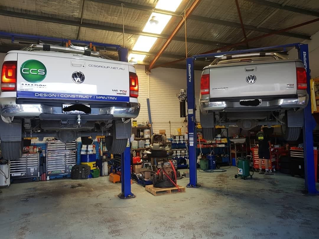 Two Trucks Are Sitting on A Lift in A Garage — Latin Motors in Fyshwick, ACT