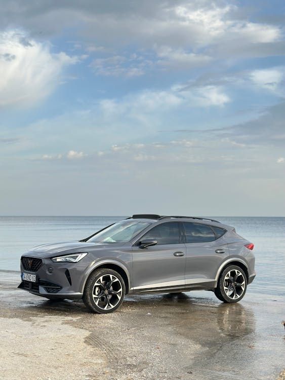 A Gray Car Is Parked on The Beach Next to The Ocean — Latin Motors in Fyshwick, ACT