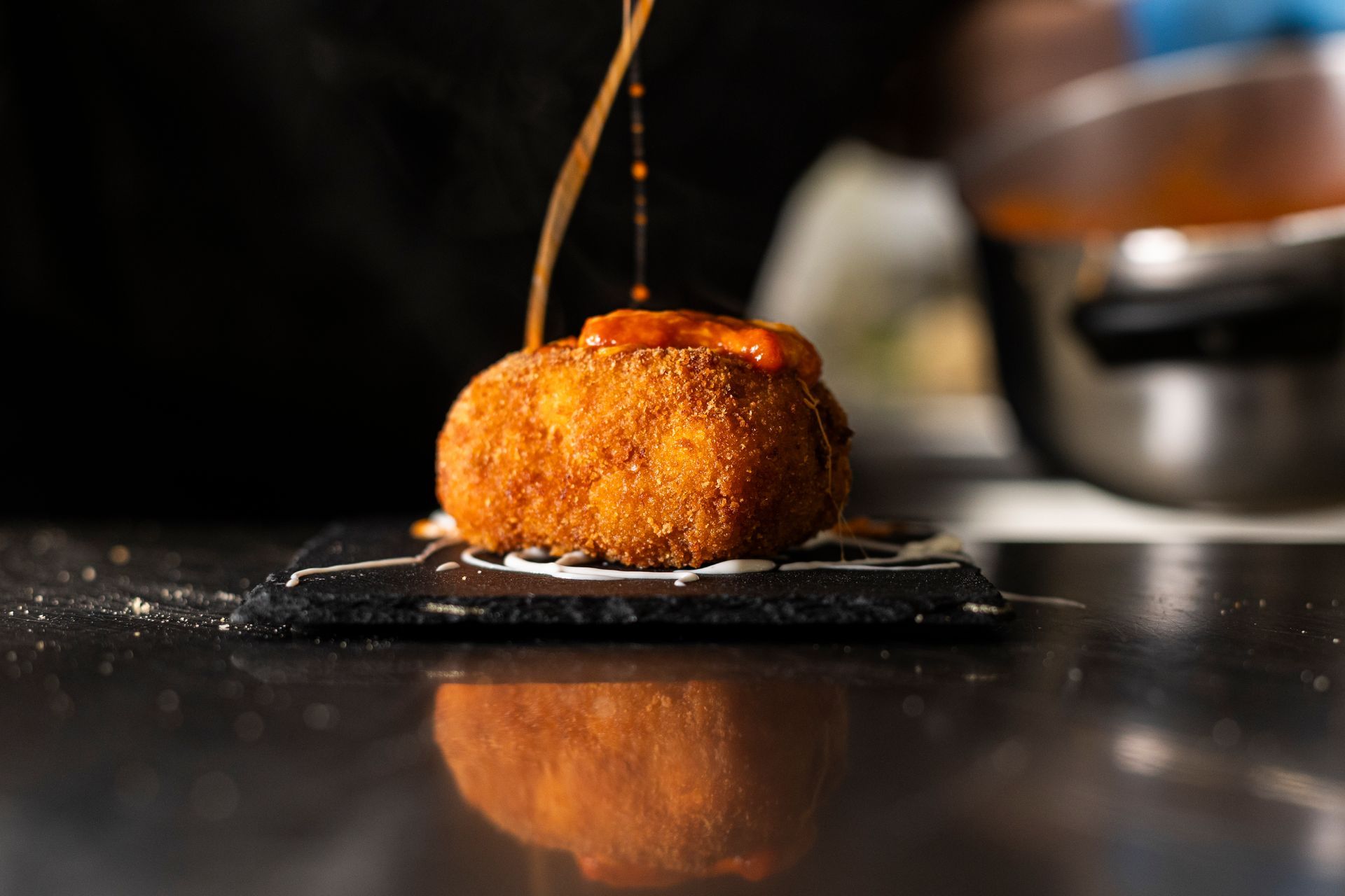 Un primo piano di un pezzo di cibo su un tavolo con la salsa versata sopra.