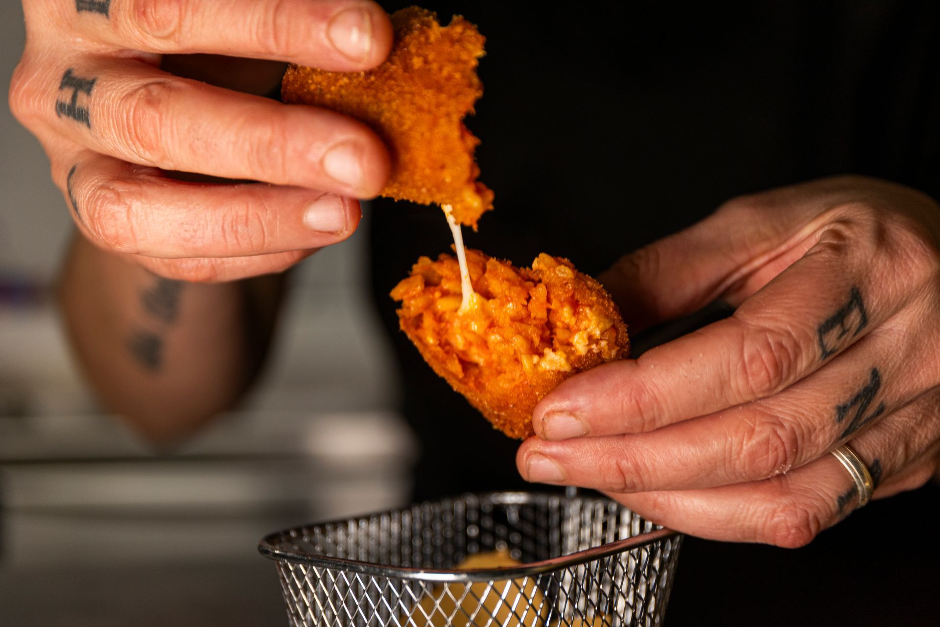 Una persona sta immergendo un pezzo di cibo in un cestino.