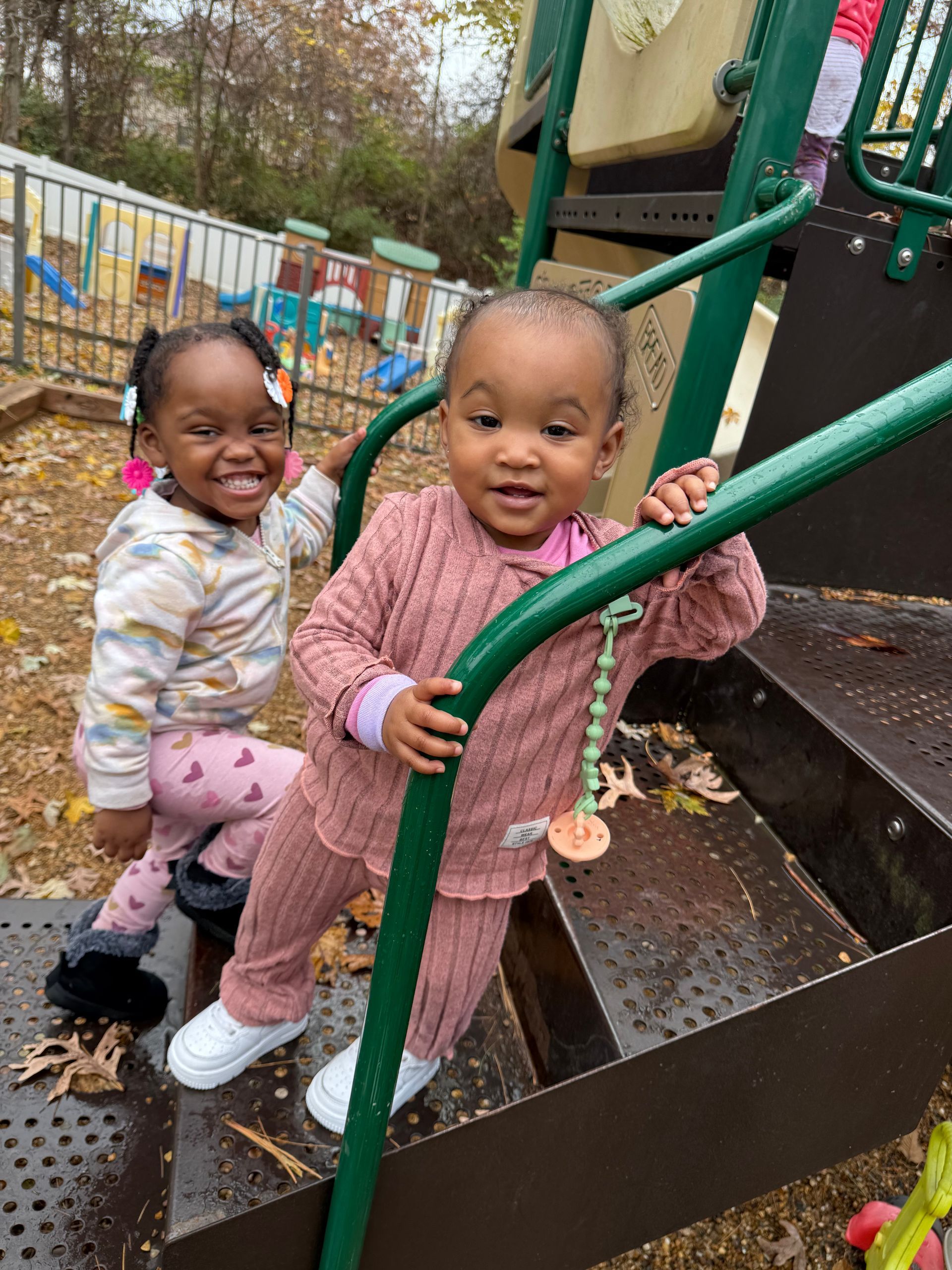 Woman and child at a table playing with toys in a colorful preschool setting.