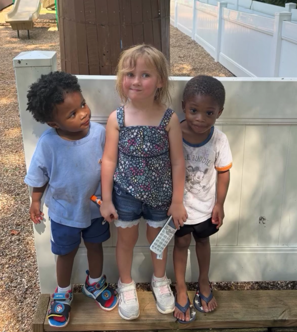 Children at a table, crafting with colorful art supplies in a brightly lit classroom.