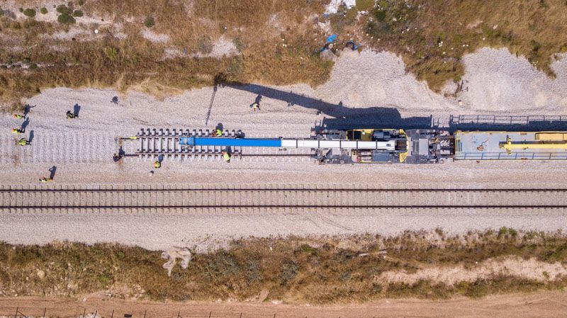 An aerial view of a train track with a crane in the background.