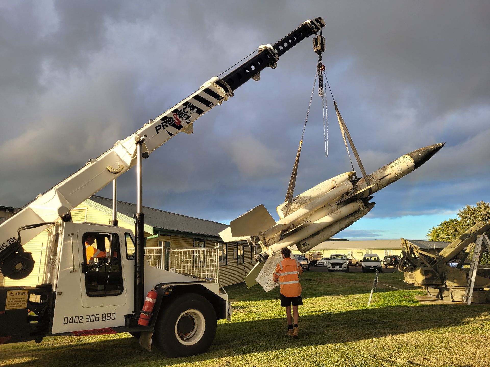 A crane is lifting a rocket into the air