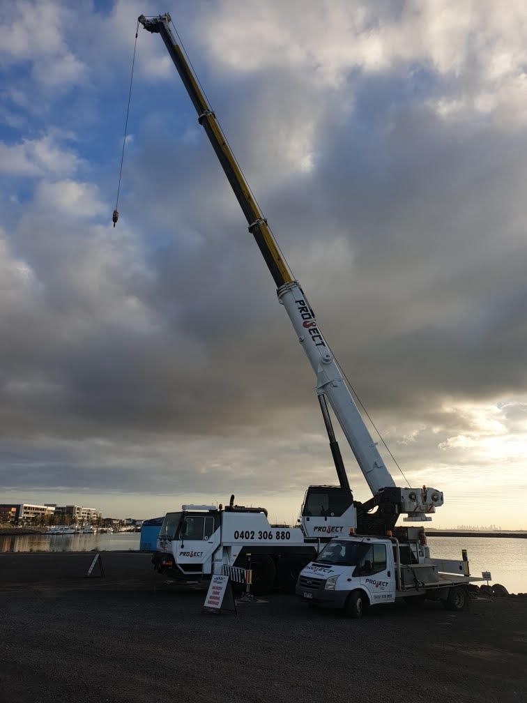 A large crane is sitting on top of a white truck.