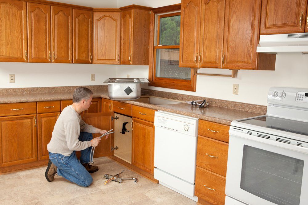 Plumber Installing Kitchen Sink — Milford, CT — Bloszko Plumbing & Heating