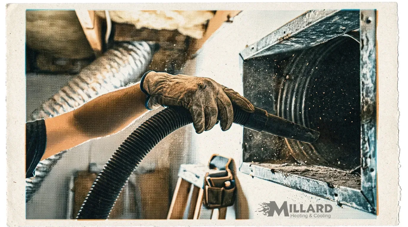hvac technician vacuuming out resdential air duct with the millard heating and air logo