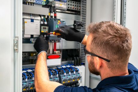 A Man Is Working On An Electrical Box With A Screwdriver – Sale, VIC - WR & EL Jones Electrical Contractors