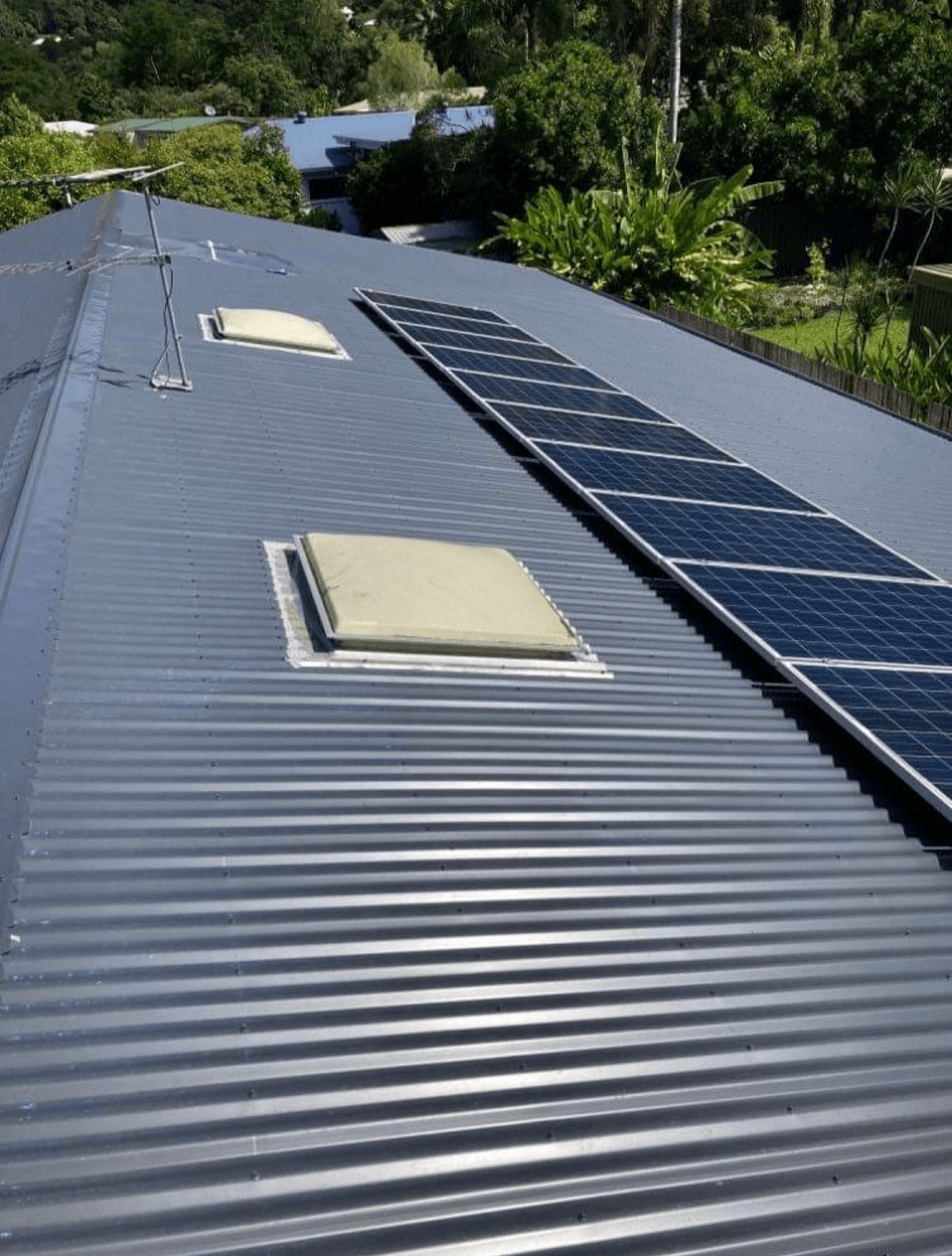 A roof with solar panels and skylights on it.