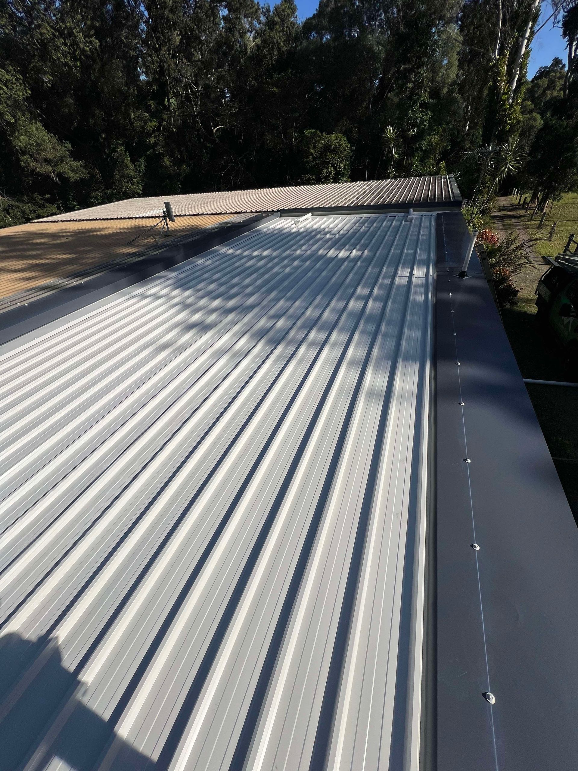 A group of men are standing in front of a row of green trucks.