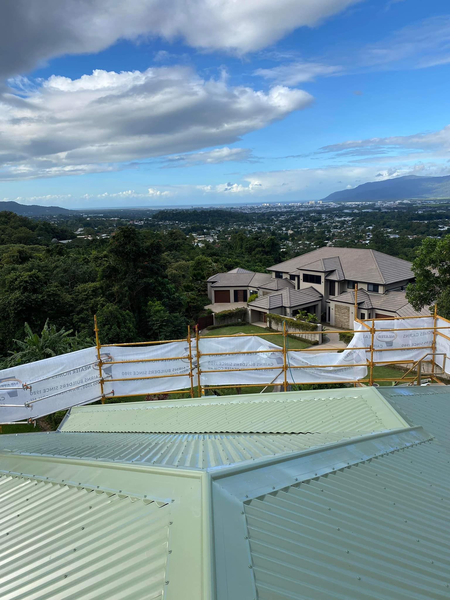 A white van is parked in front of a white roof.