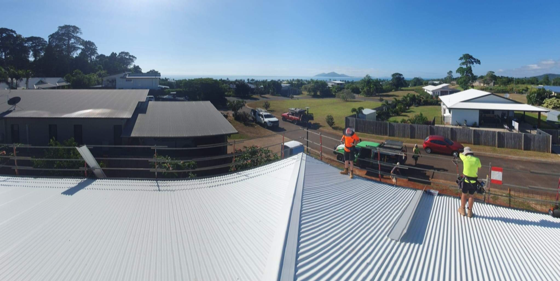 A group of people are working on the roof of a house.