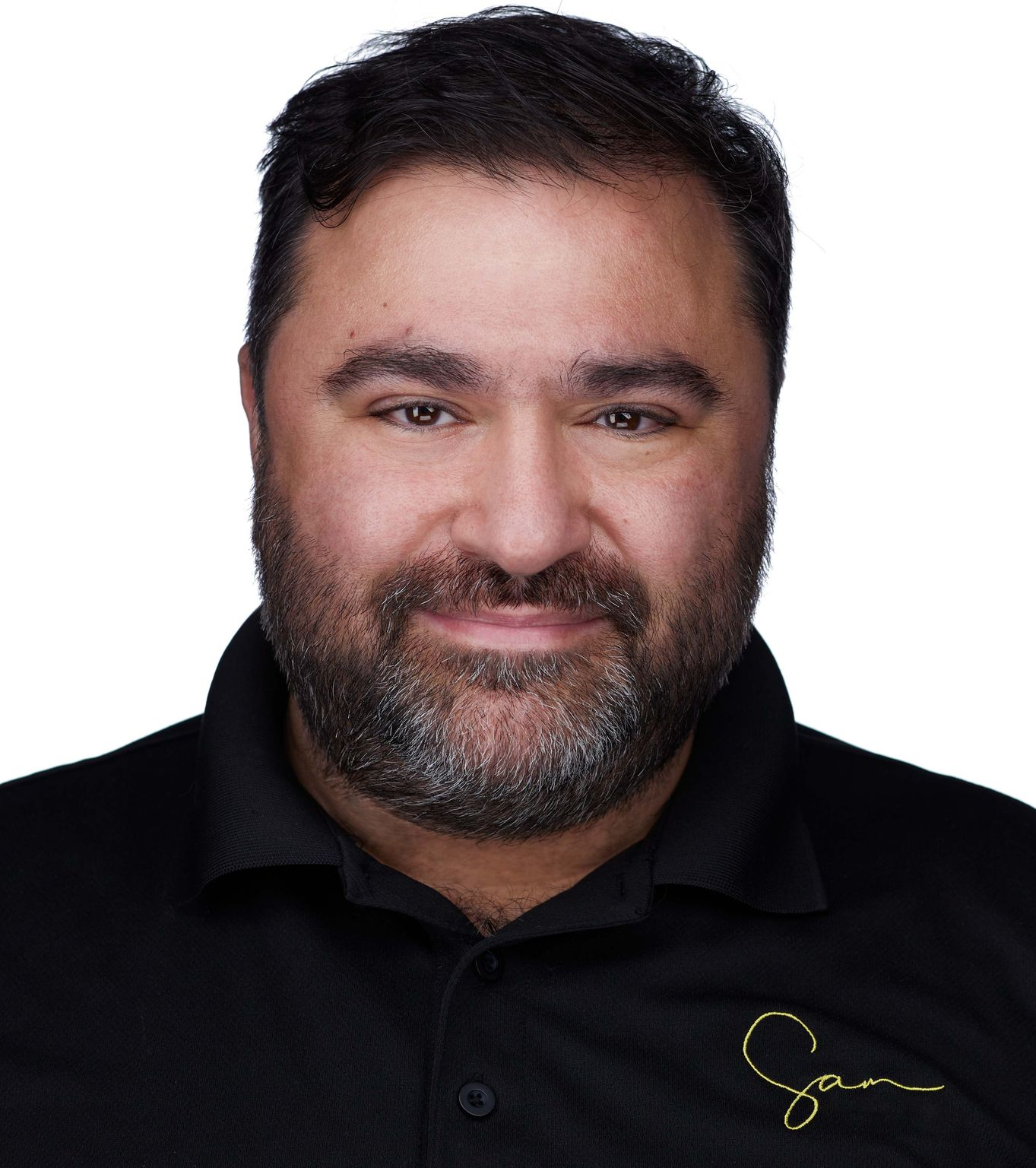 Sam Fatima Man with dark hair and beard smiling, wearing a black shirt with a gold logo.