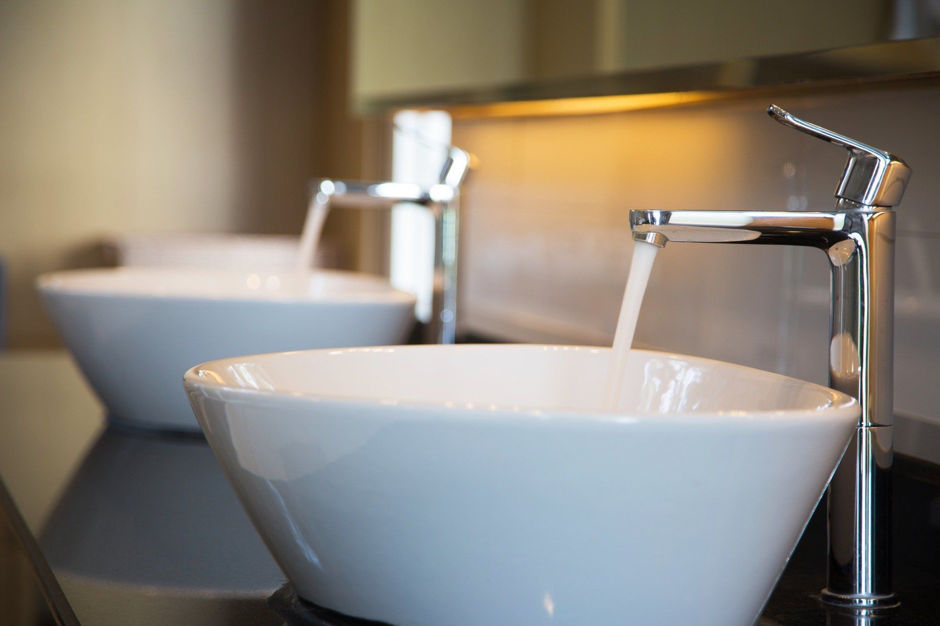 Due lavabi in ceramica bianca con rubinetti cromati in un bagno o una toilette moderna.