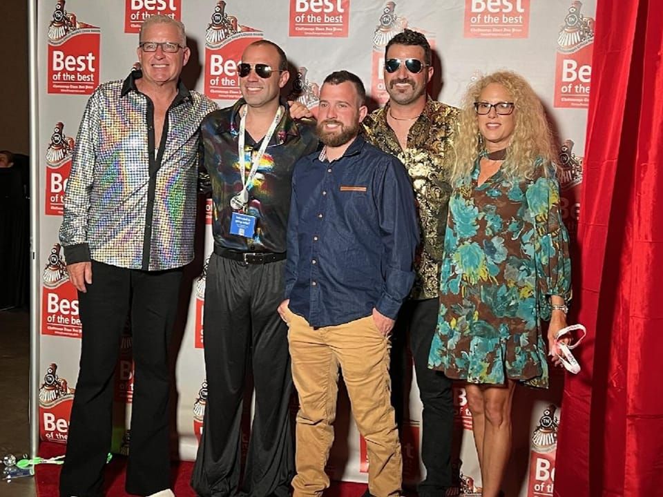 A group of people are posing for a picture on a red carpet.