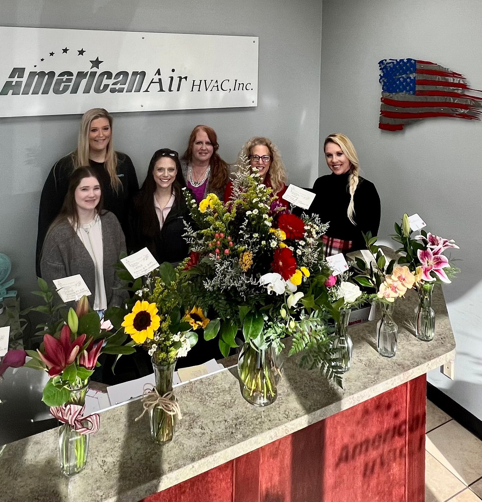 A group of women standing in front of a sign that says american air