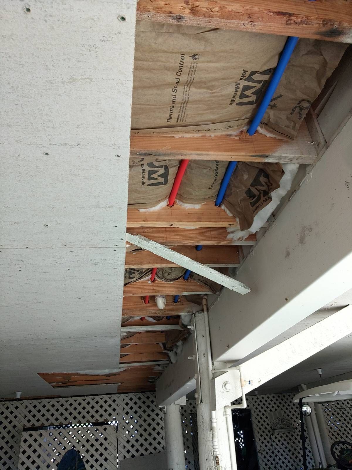 A white wall with a lot of pipes hanging from it.