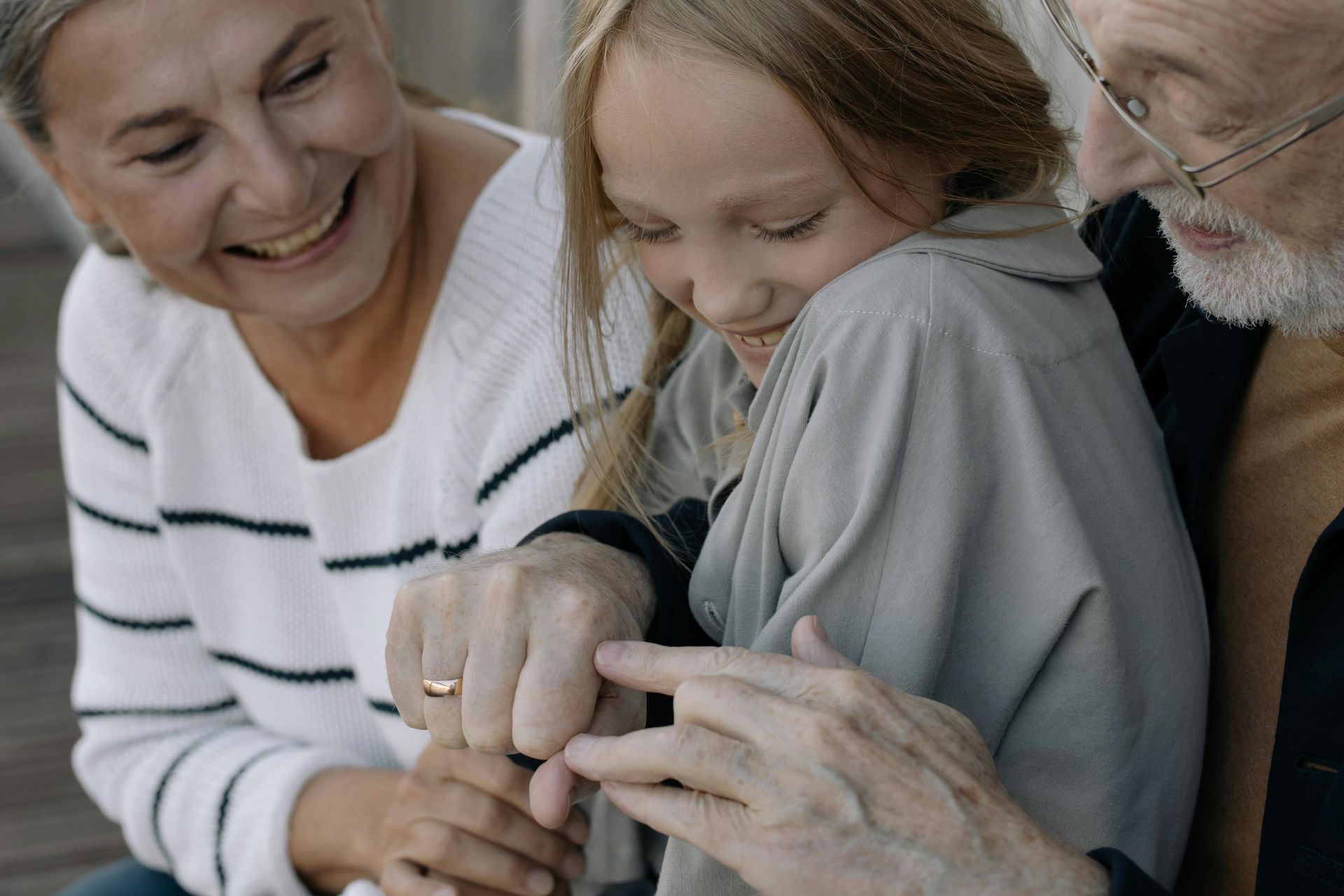 An elderly couple and a young girl are sitting next to each other.