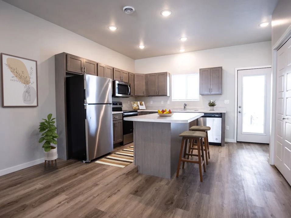 A kitchen with stainless steel appliances and a large island.