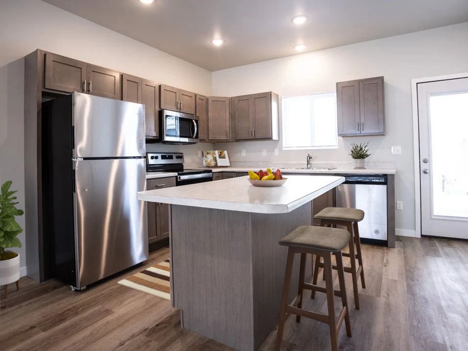 A kitchen with stainless steel appliances and a large island.