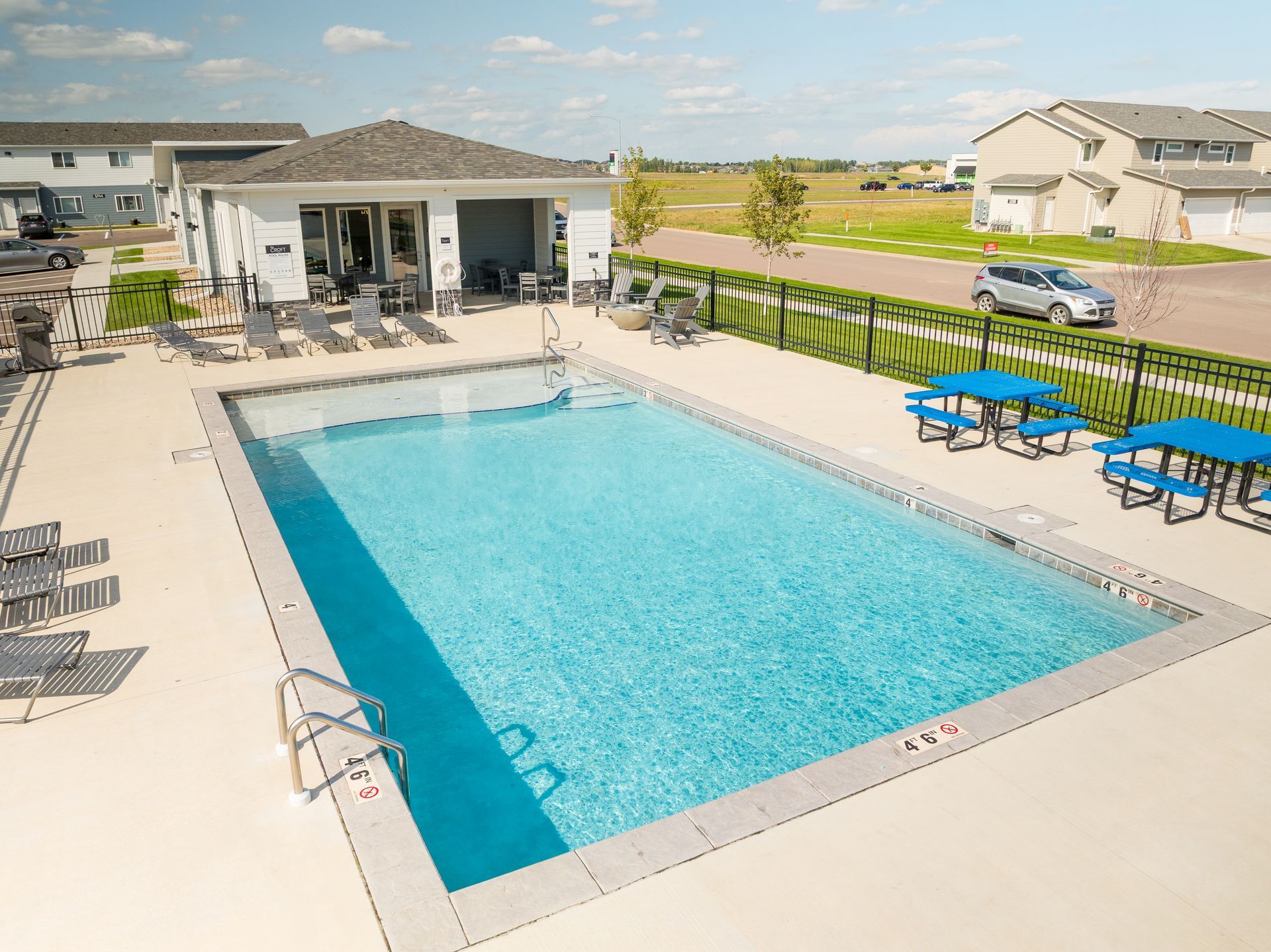 Outdoor pool with picnic tables.