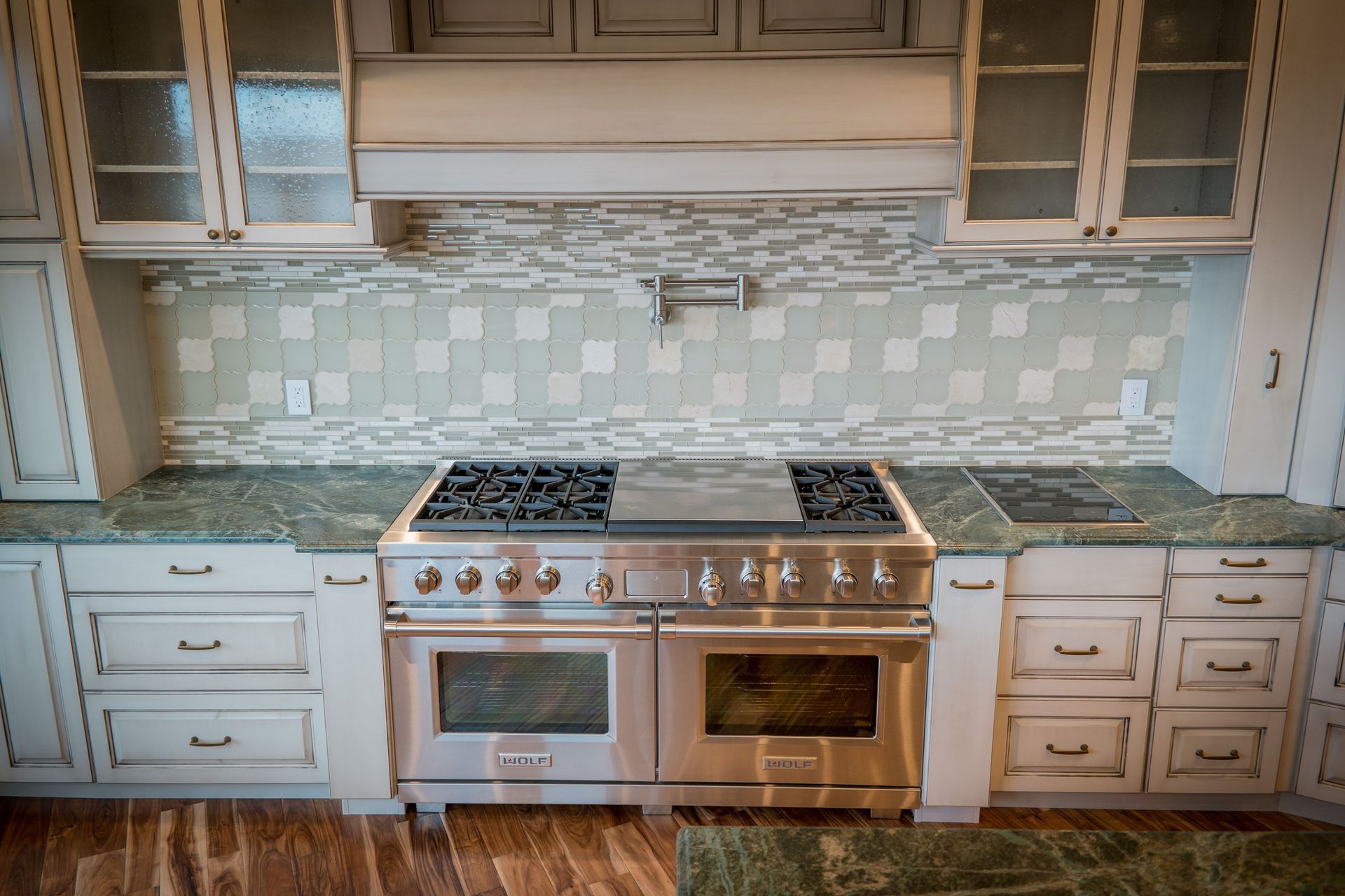 Kitchen with stainless steel range, gray cabinets, and green countertops.