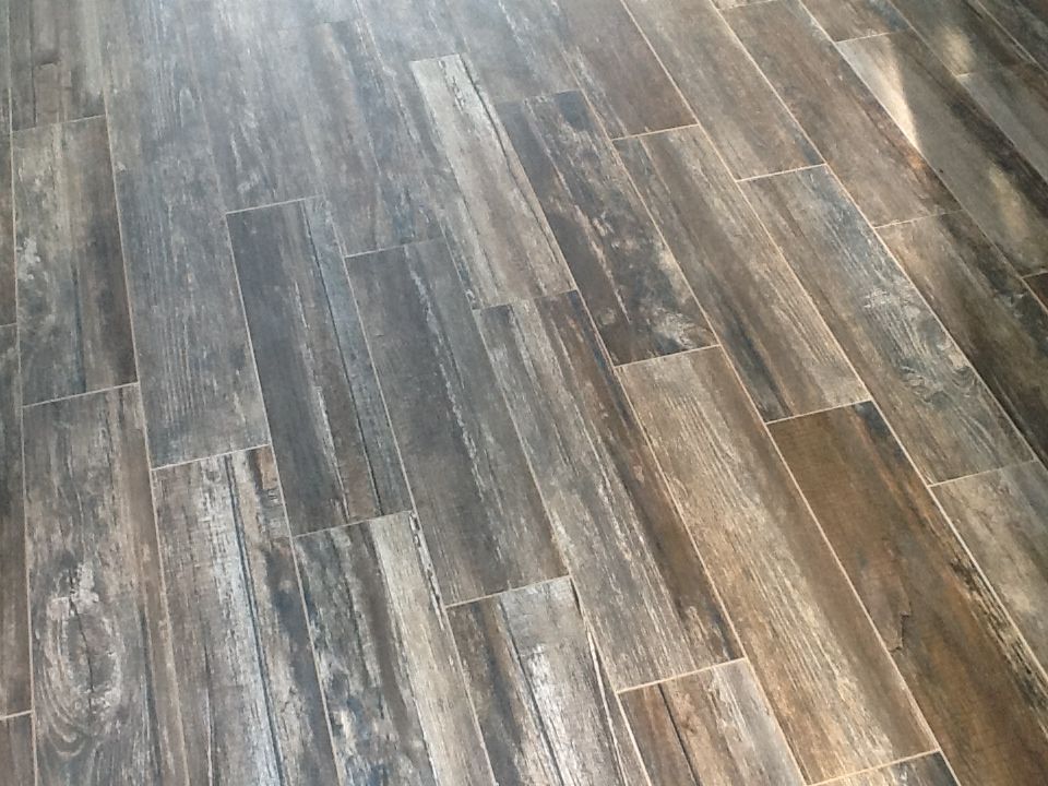 Wood-look tile flooring in shades of brown and gray, installed in a staggered pattern.