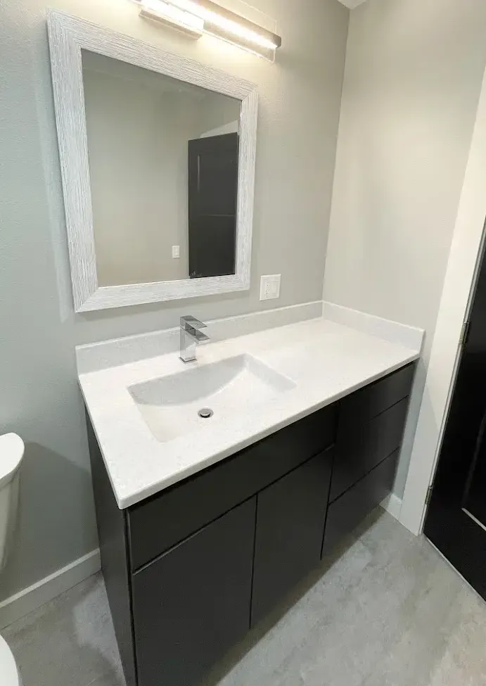 A bathroom with a sink , mirror and toilet.