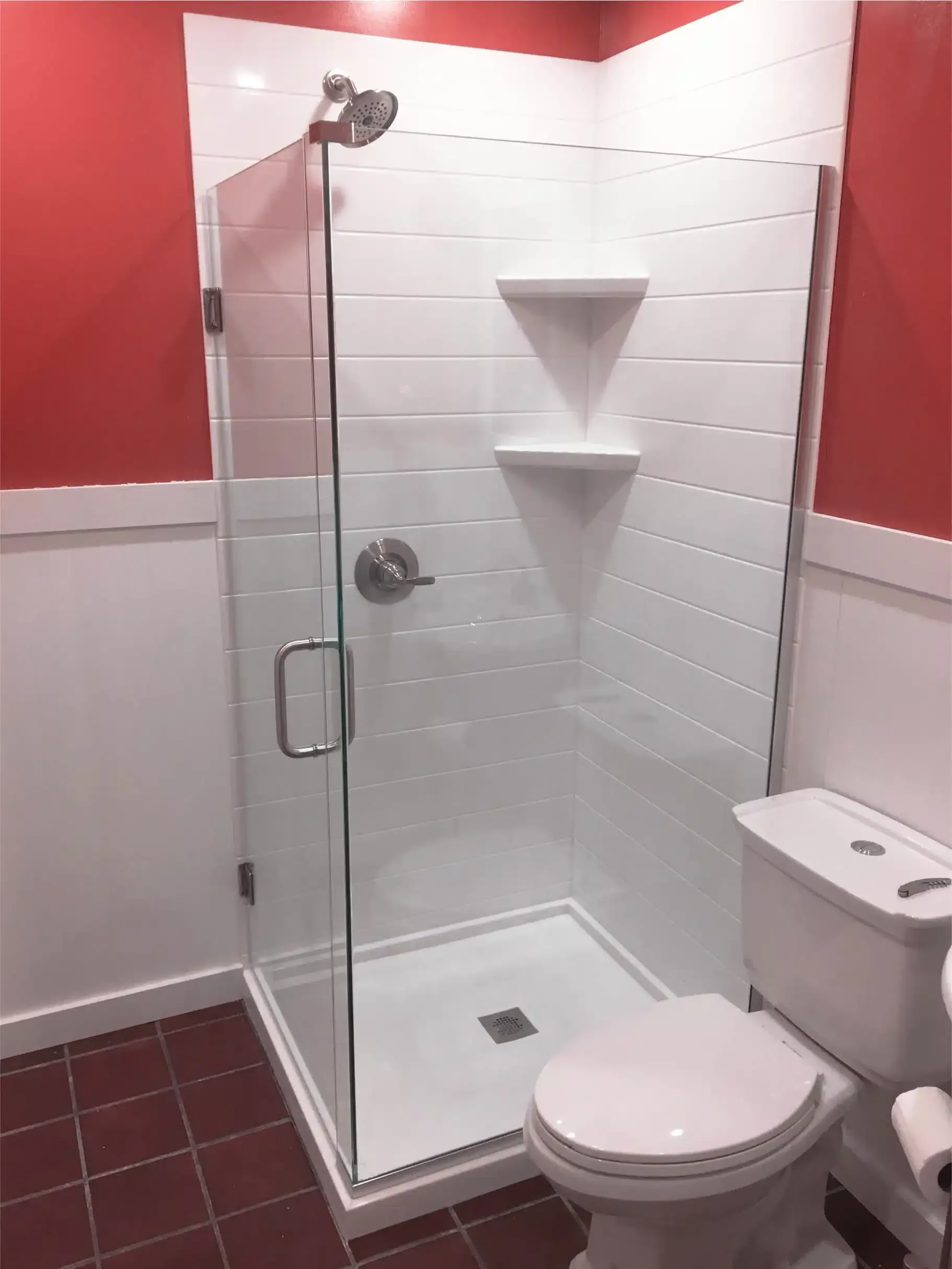 A bathroom with a toilet and a shower with a glass door