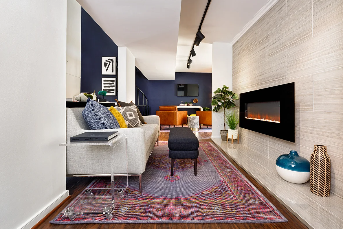 A living room with a couch , rug and fireplace.