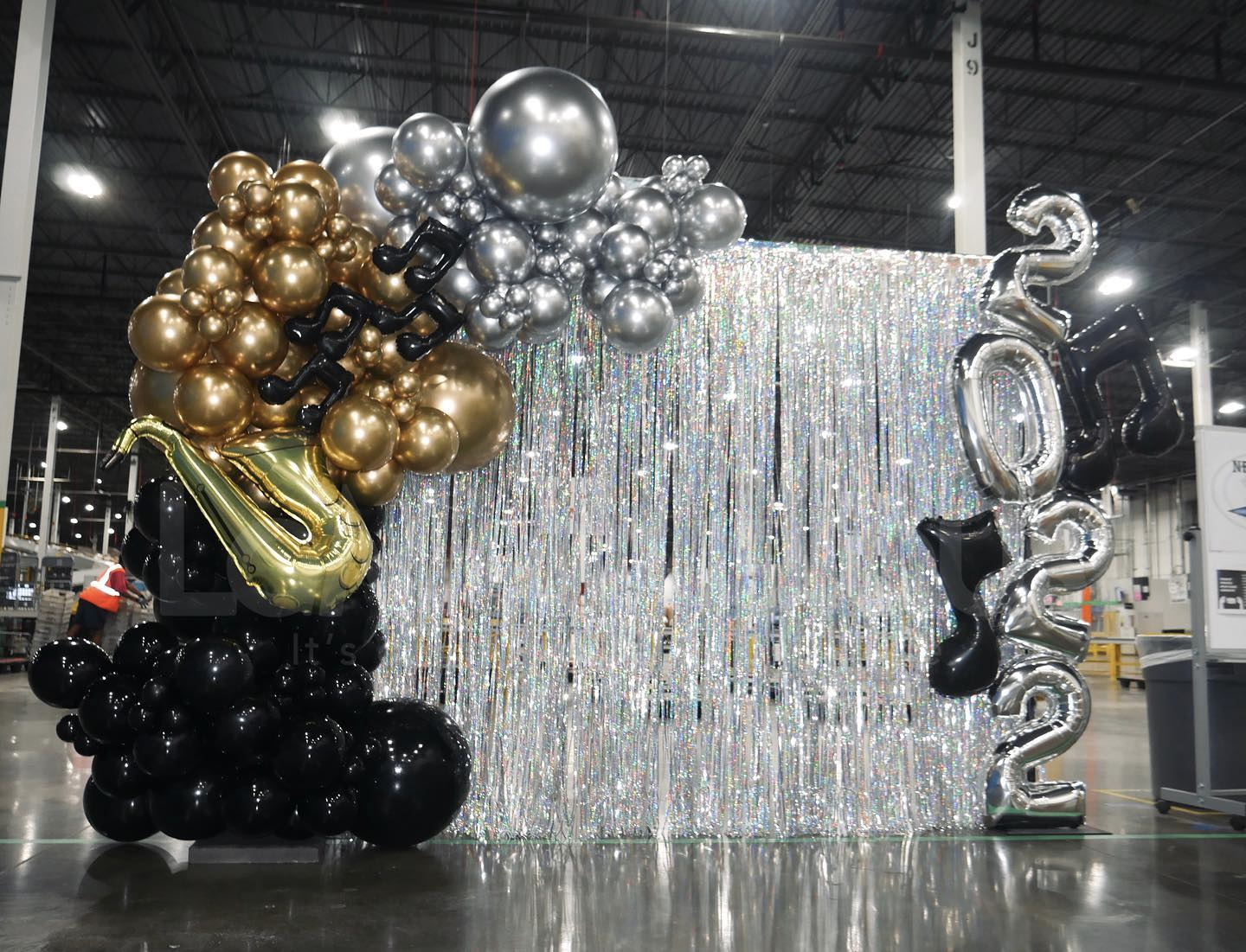A bunch of balloons are sitting in front of a wall.