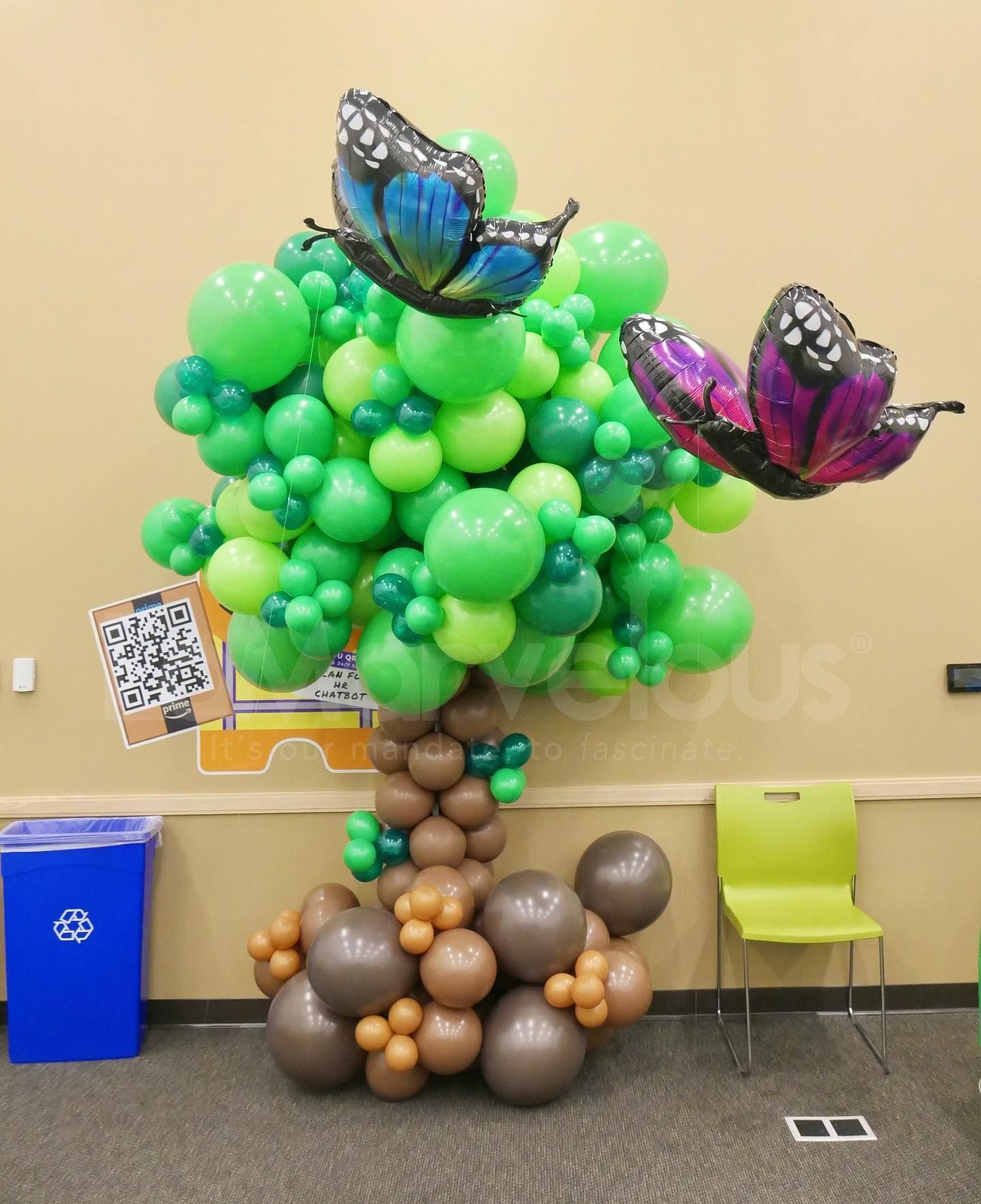 A tree made of balloons with butterflies on top