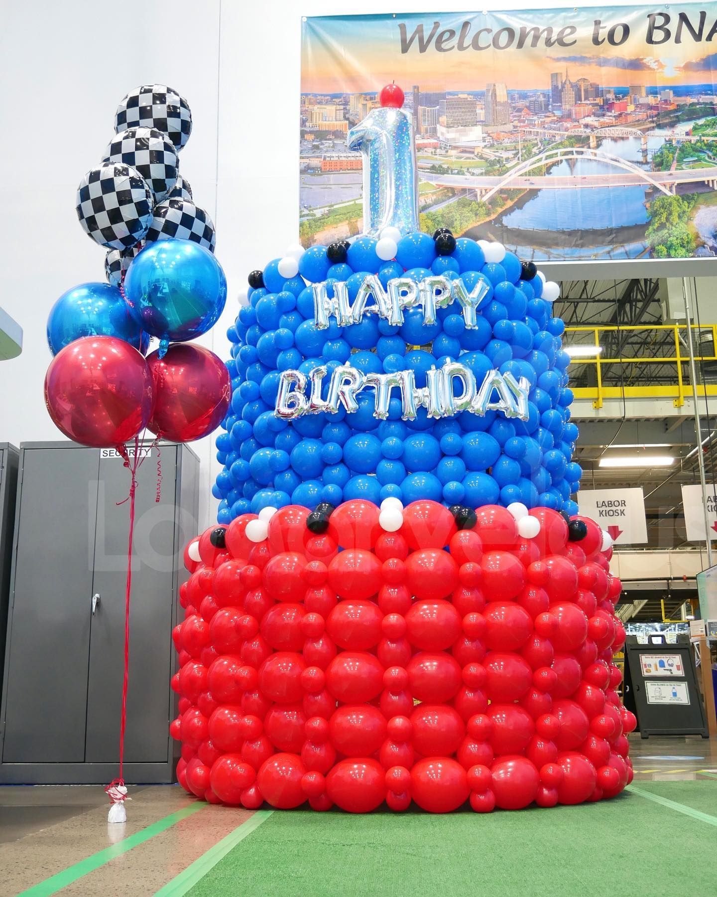 A large birthday cake made of red , blue and white balloons.