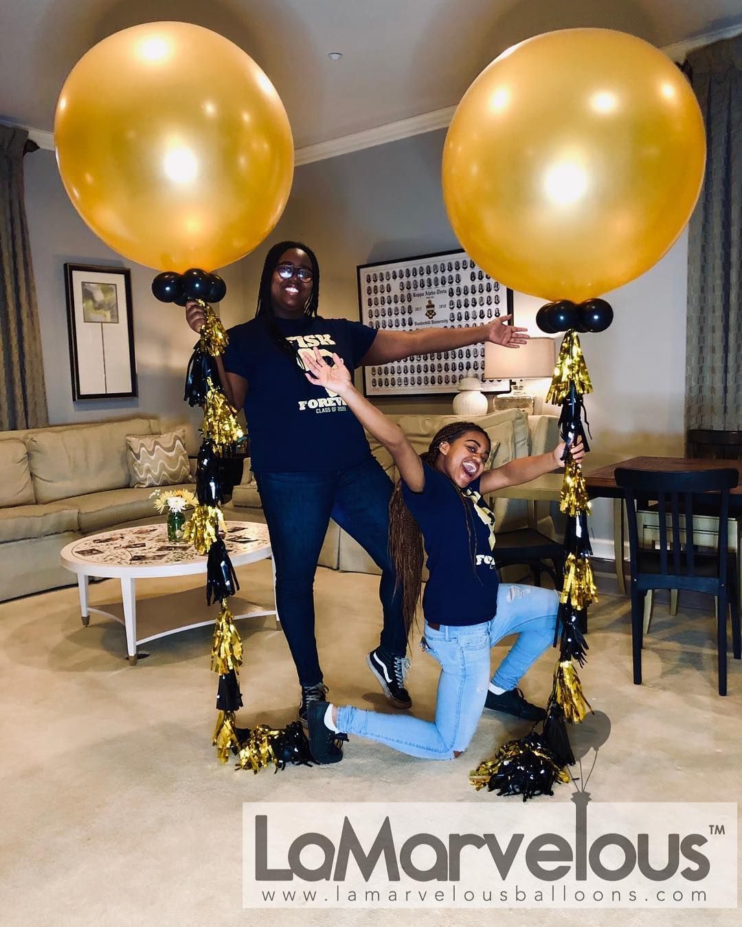 A woman and a child are posing for a picture with gold balloons in a living room.