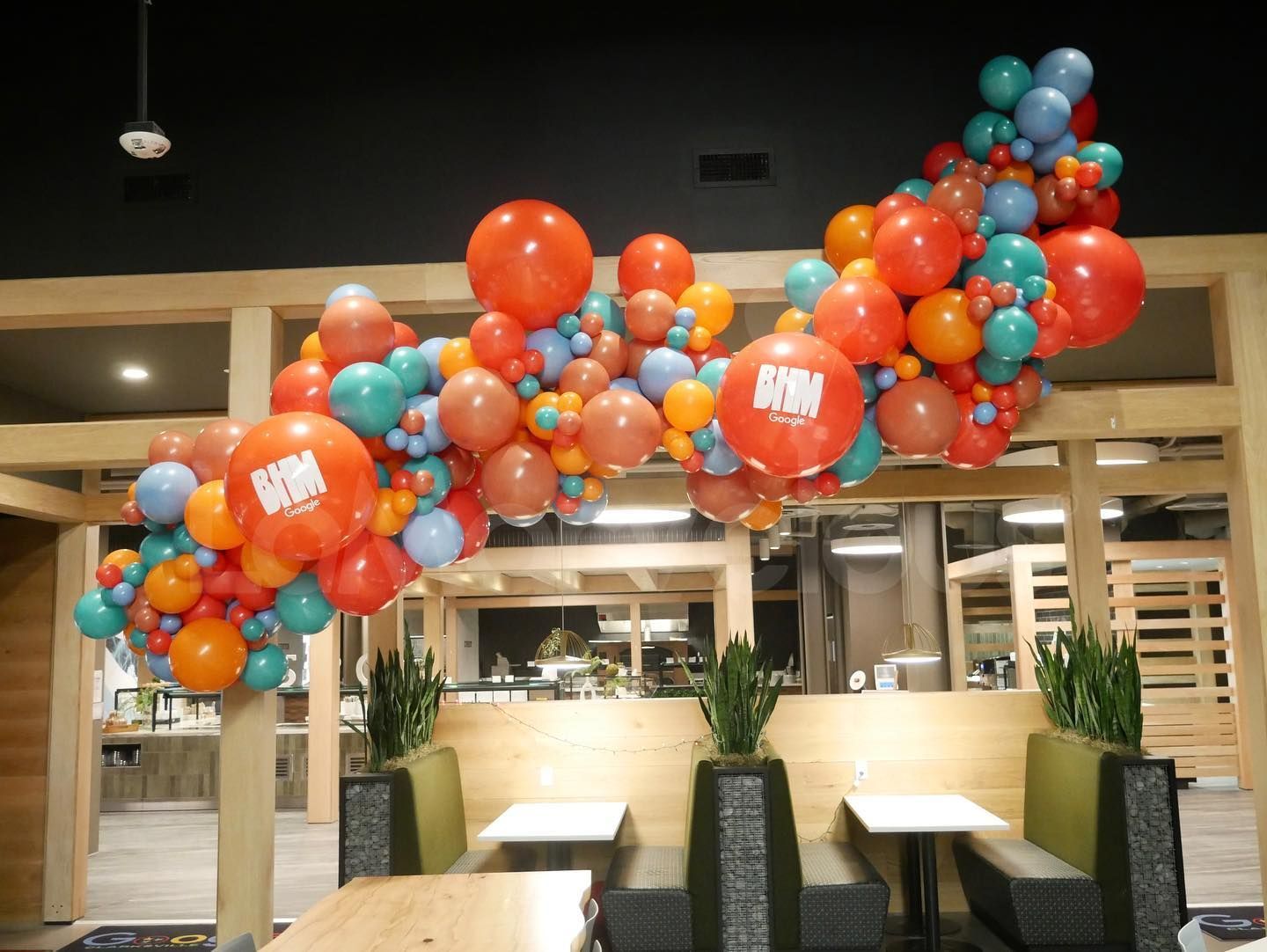 A bunch of balloons are hanging from the ceiling in a restaurant