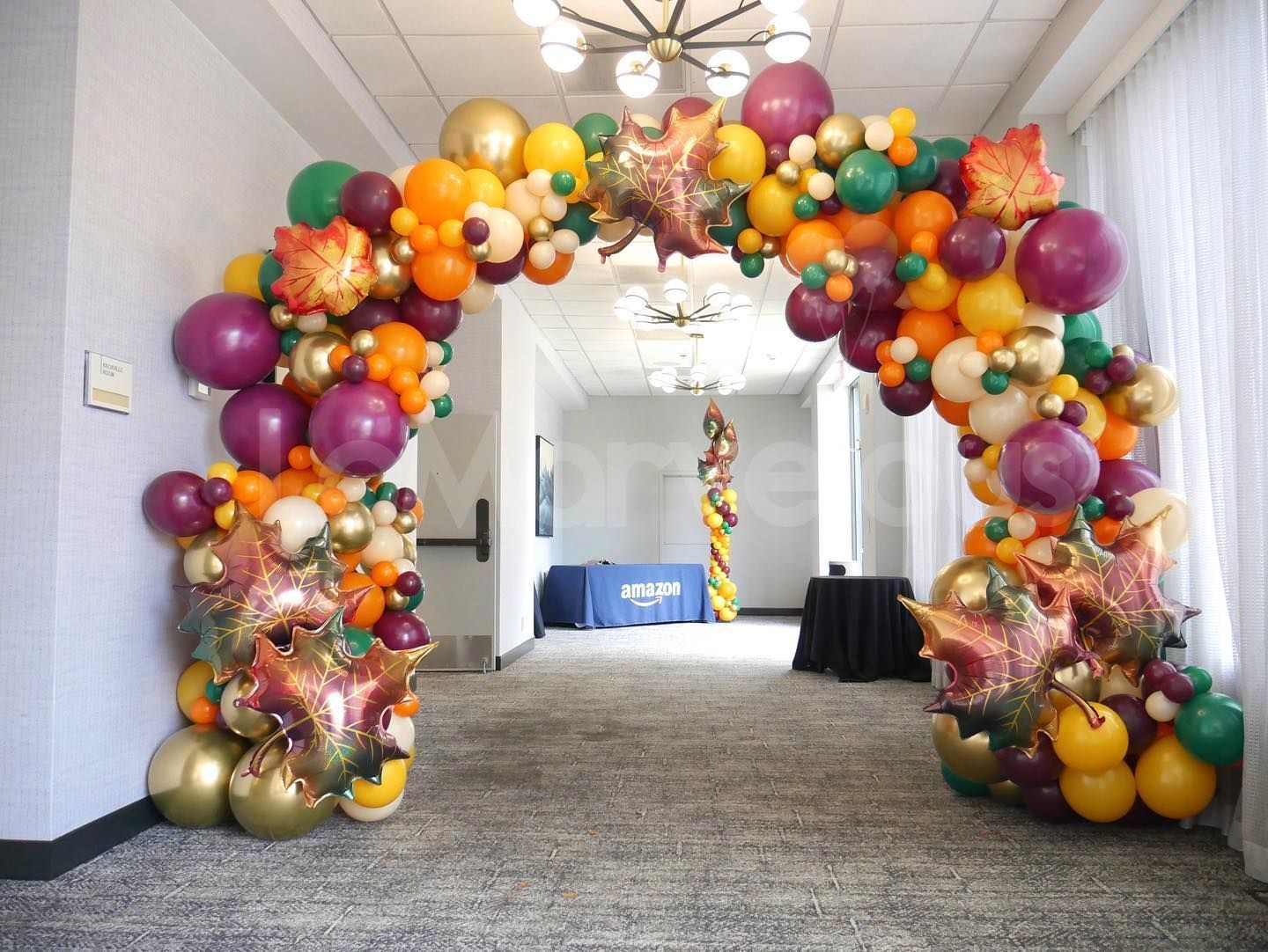 A hallway filled with balloons and a balloon arch.