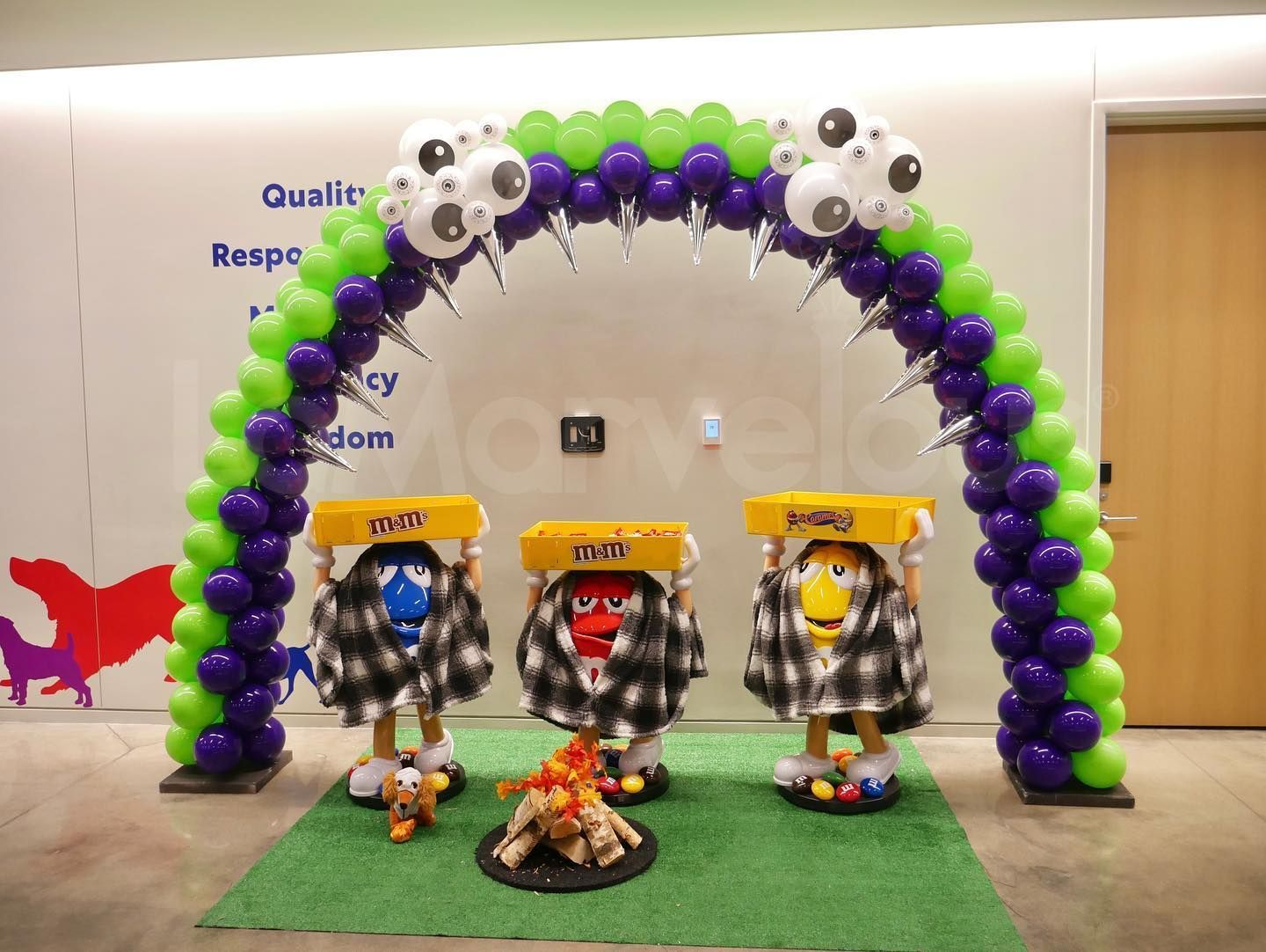 A bunch of balloons are lined up in a room