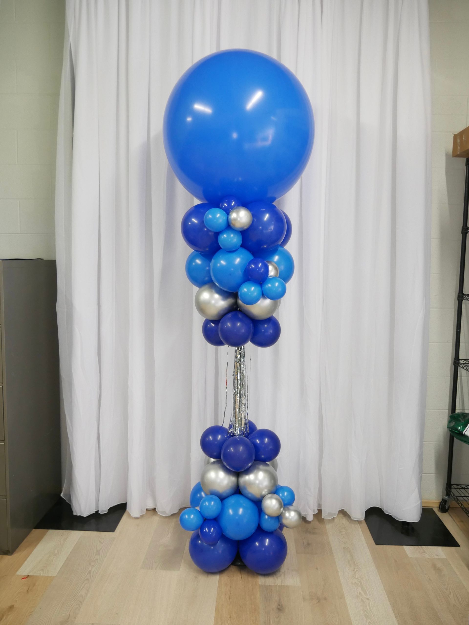 Blue and silver balloons are stacked on top of each other